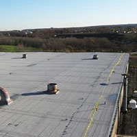 Mod-Bit commercial roof installation by CentiMark over a factory