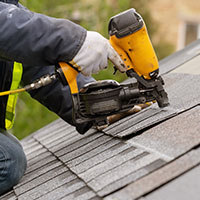 Roofer installing shingles on a roof