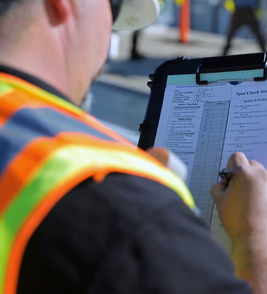 roofing tech looking at checklist when evaluating commercial roof