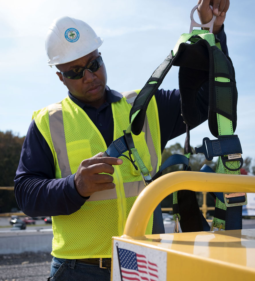 African American roofer checking safety equipment