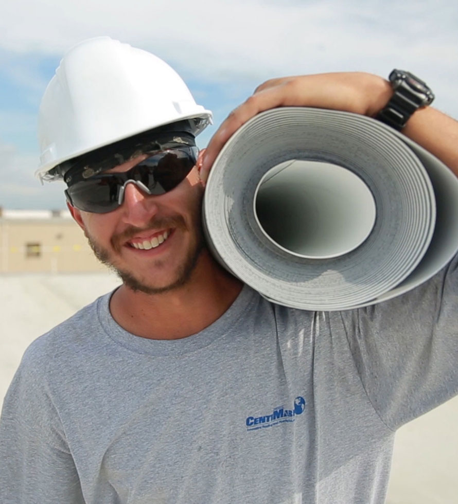 commercial roofer with TPO membrane roll looking at a camera