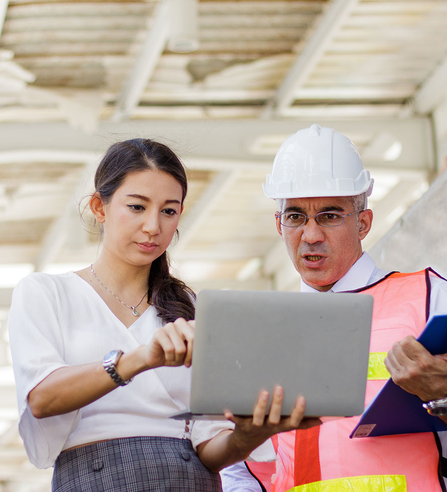 female engineer and a construction foreman looking at laptop