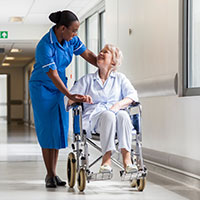 a nurse comforting an elderly woman in a wheelchair