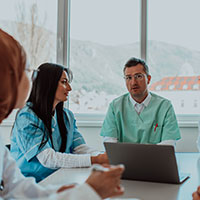 a group of hospital associates discuss their strategy in a conference room