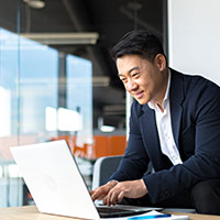 business man smiling looking at the laptop