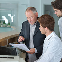 hotel staff looking at a roof warranty contract