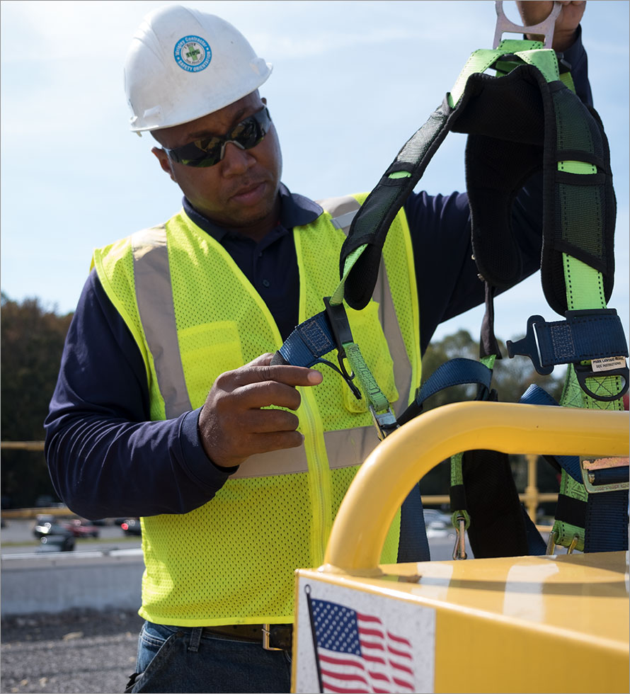 centimark commercial roofer is checking safety harness 