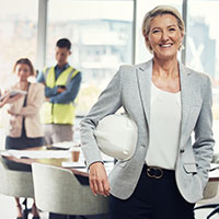 business woman with a construction hard hat looking at the screen