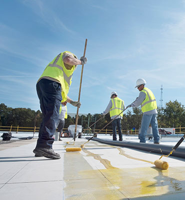 CentiMark roofing crew installing a TPO roof on a manufacturing facility