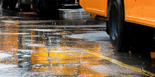 raining on the parking lot with school buses parked