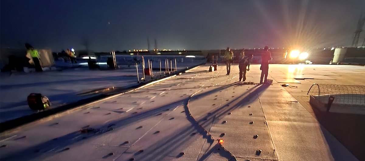 commercial roofers working at night to avoid overheating during a heat wave