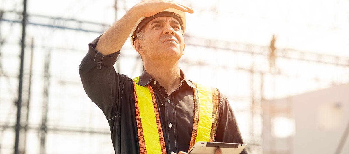 construction worker looking up shielding his eyes